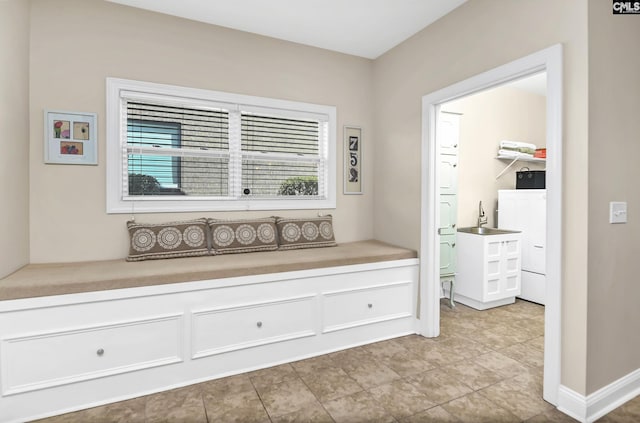 interior space with washer / clothes dryer, a sink, and baseboards