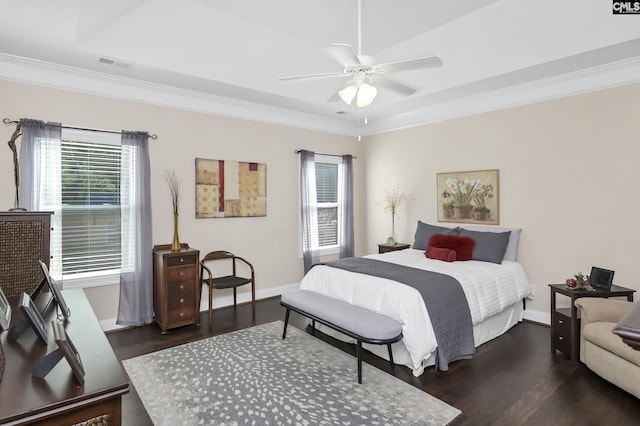 bedroom with baseboards, visible vents, ceiling fan, wood finished floors, and crown molding