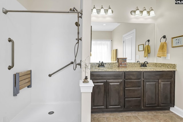 bathroom featuring a shower, tile patterned floors, a sink, and double vanity