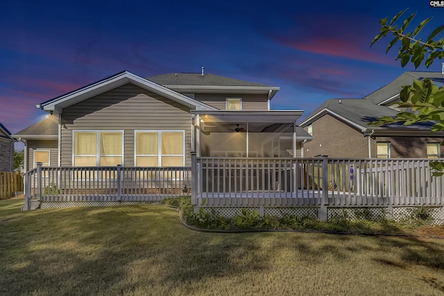 rear view of house with a lawn and a wooden deck