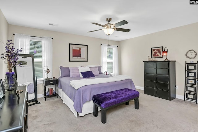 bedroom featuring light carpet, a ceiling fan, visible vents, and baseboards