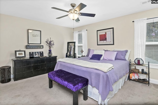 carpeted bedroom with a ceiling fan, visible vents, and baseboards