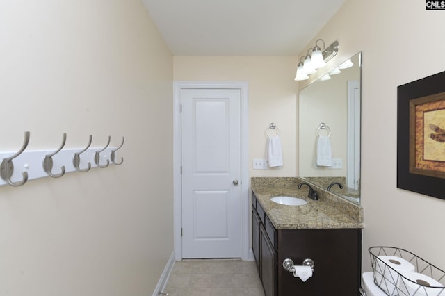 bathroom featuring toilet, vanity, and baseboards