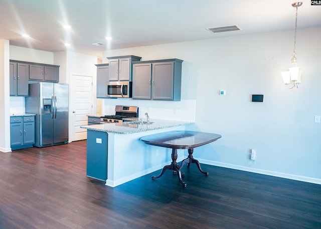 kitchen featuring a peninsula, a sink, visible vents, appliances with stainless steel finishes, and dark wood finished floors