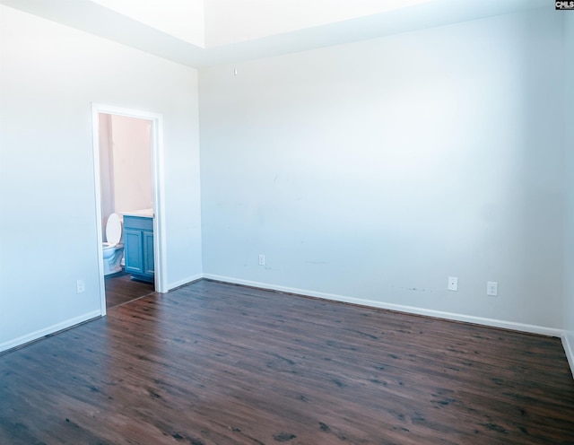 empty room featuring dark wood-type flooring and baseboards