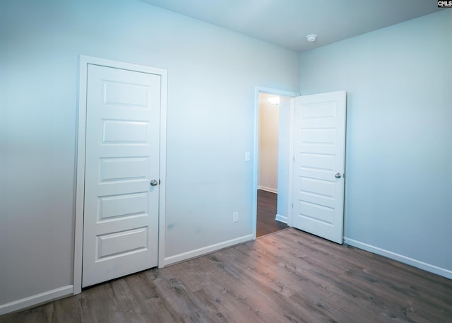 unfurnished bedroom featuring wood finished floors and baseboards