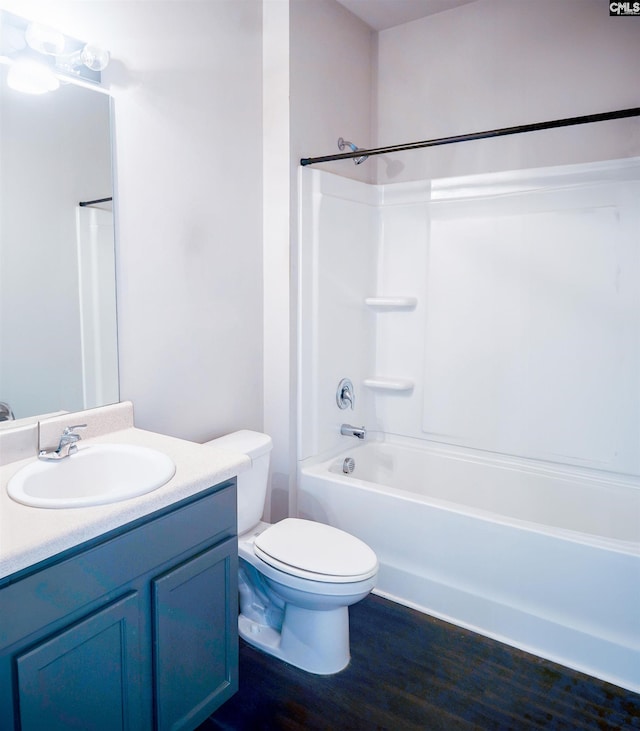 full bathroom with toilet, washtub / shower combination, wood finished floors, and vanity