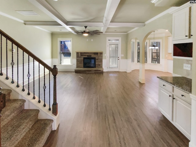 150 Grey Oaks Ln, Lexington, SC 29072 - unfurnished living room with a stone fireplace, a wainscoted wall, coffered ceiling, beam ceiling, and dark wood finished floors