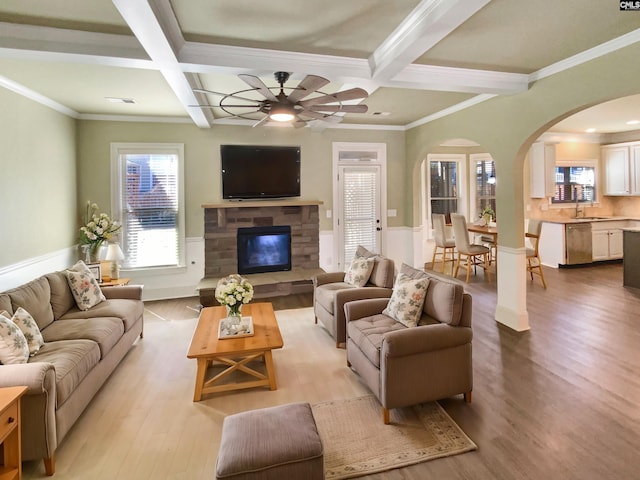 living area featuring plenty of natural light, light wood finished floors, coffered ceiling, and beam ceiling