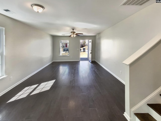 interior space with baseboards, stairs, visible vents, and wood finished floors