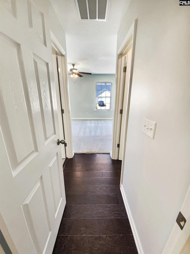 hallway with baseboards and dark wood-style flooring