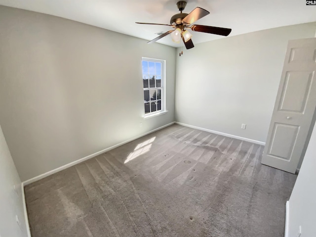 empty room with a ceiling fan, carpet floors, and baseboards