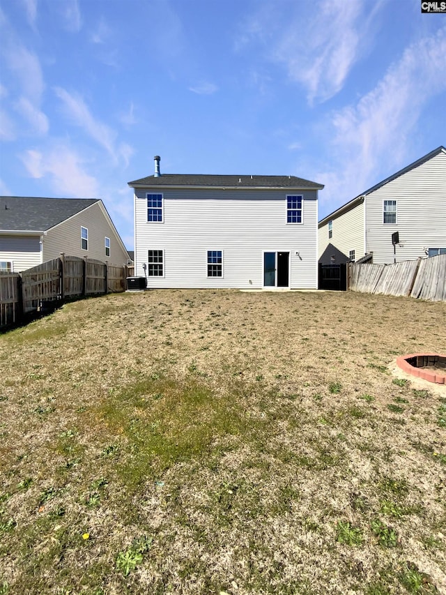 back of property featuring a fenced backyard and a yard