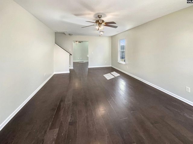 unfurnished living room featuring dark wood-style floors, ceiling fan, and baseboards