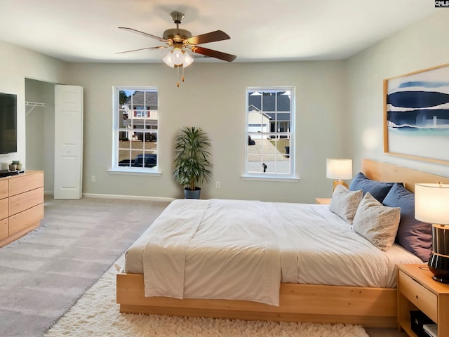 carpeted bedroom with a ceiling fan and baseboards