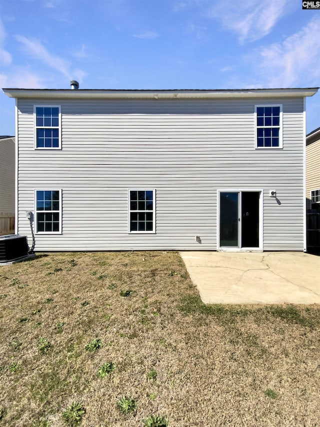 rear view of property featuring a patio, a yard, and central AC unit