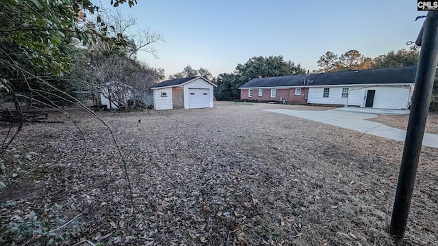 view of yard with a garage, gravel driveway, and an outdoor structure