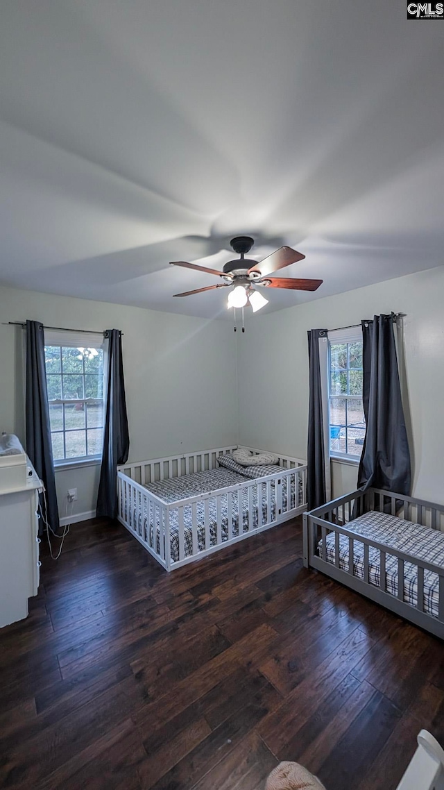 unfurnished bedroom with hardwood / wood-style floors, a ceiling fan, and baseboards