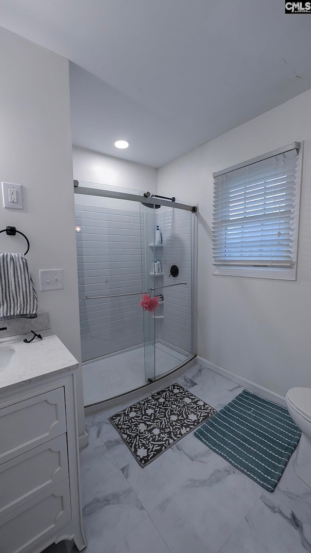 full bathroom featuring toilet, vanity, baseboards, marble finish floor, and a shower stall