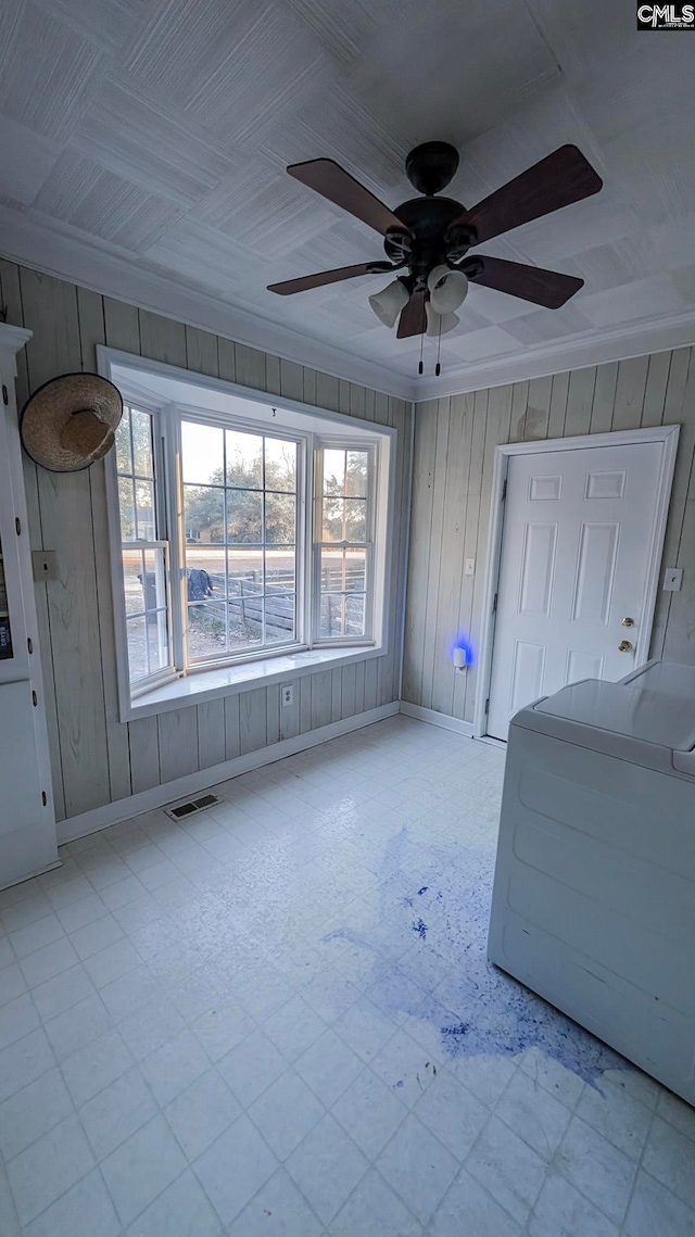 interior space with crown molding, visible vents, washer / dryer, baseboards, and tile patterned floors