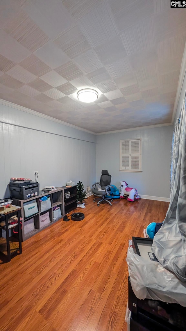 interior space with ornamental molding and wood finished floors