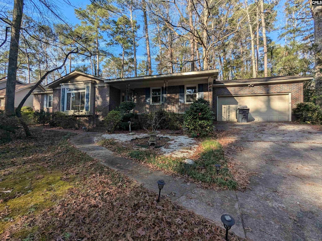 view of front of home with driveway, an attached garage, and brick siding