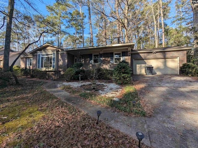 view of front of home with driveway, an attached garage, and brick siding