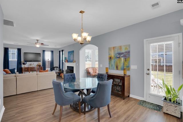 dining area with plenty of natural light, visible vents, a fireplace, and light wood finished floors