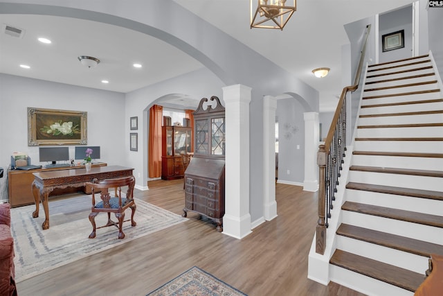 office space featuring arched walkways, recessed lighting, and wood finished floors