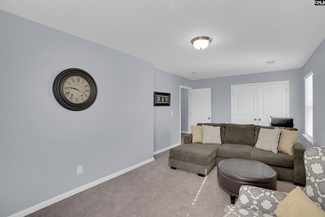 carpeted living area with baseboards