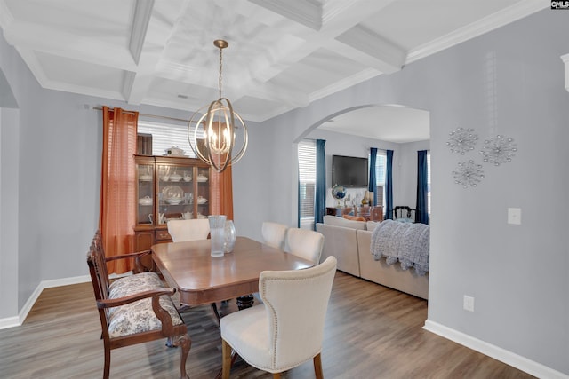 dining area featuring light wood-style floors, arched walkways, baseboards, and an inviting chandelier