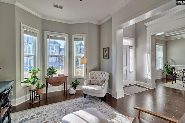 living area featuring ornamental molding, baseboards, a healthy amount of sunlight, and hardwood / wood-style floors