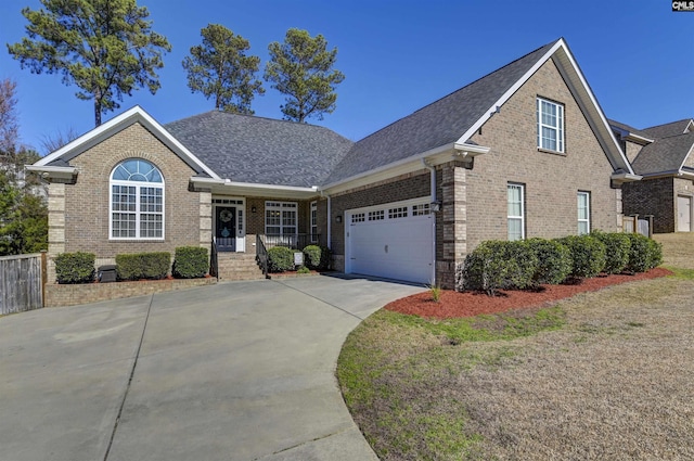 view of front of home featuring brick siding, roof with shingles, concrete driveway, an attached garage, and fence