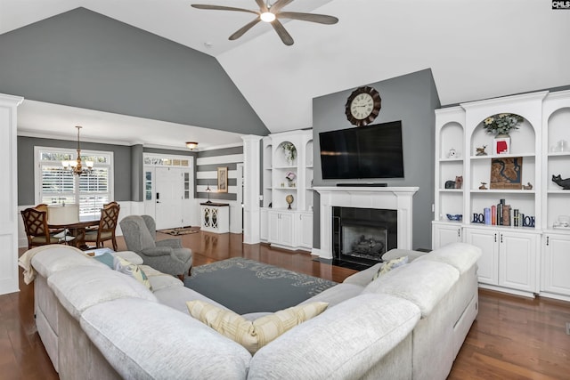 living area featuring a tile fireplace, vaulted ceiling, dark wood finished floors, and ceiling fan with notable chandelier