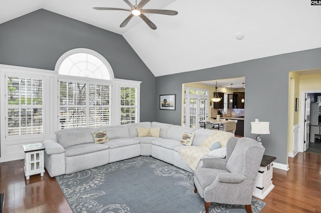 living room with dark wood-style floors, baseboards, high vaulted ceiling, and a ceiling fan