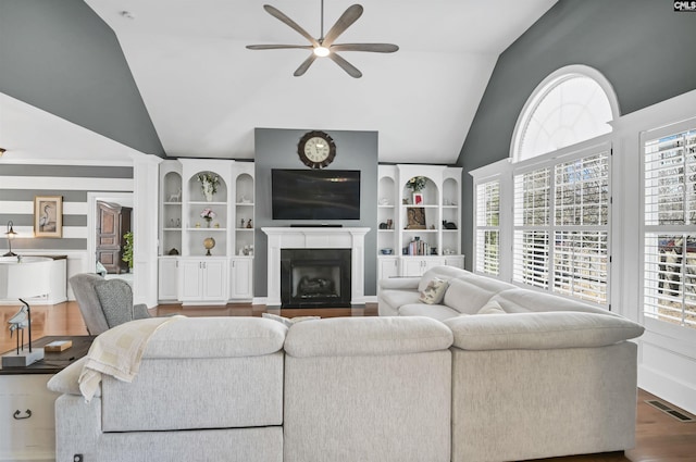 living room with a fireplace with flush hearth, lofted ceiling, visible vents, and wood finished floors