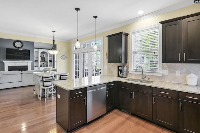 kitchen with dishwasher, a sink, light wood-style flooring, and crown molding