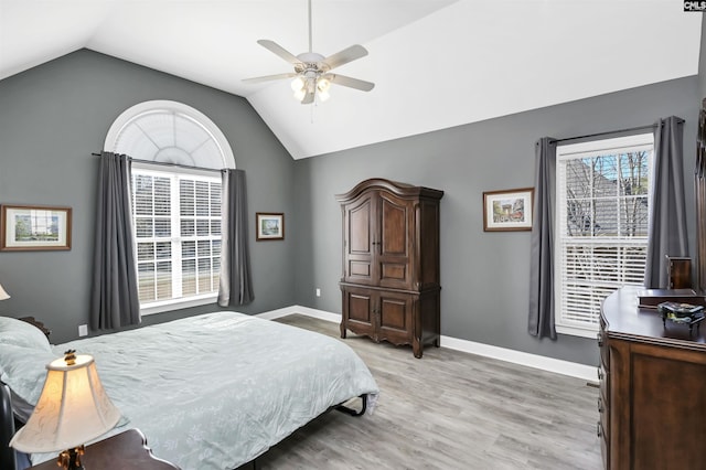 bedroom with lofted ceiling, light wood finished floors, baseboards, and a ceiling fan