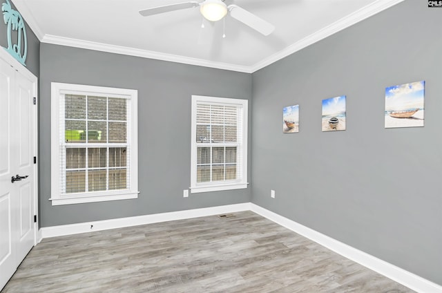 unfurnished room featuring light wood-style floors, baseboards, ornamental molding, and a ceiling fan