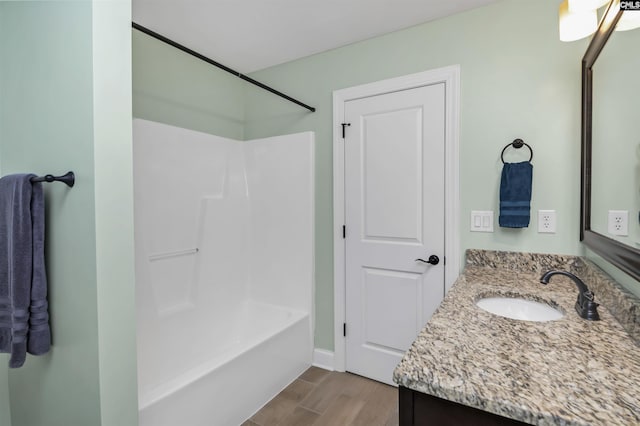 bathroom featuring washtub / shower combination, vanity, and wood finished floors