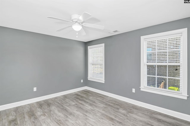 empty room with visible vents, plenty of natural light, and baseboards