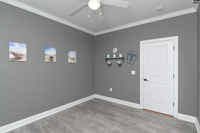 spare room featuring baseboards, ornamental molding, and wood finished floors