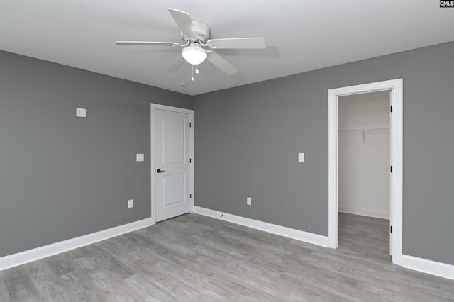 spare room featuring ceiling fan, baseboards, and wood finished floors