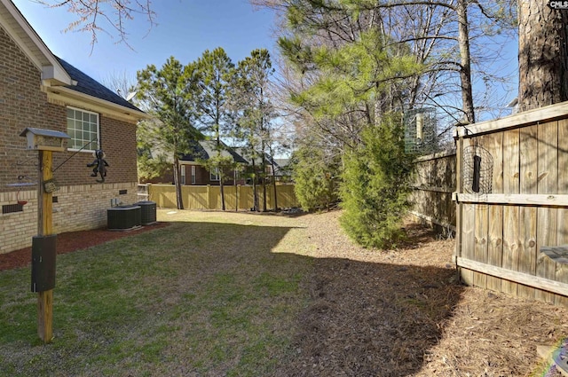 view of yard with central air condition unit and fence