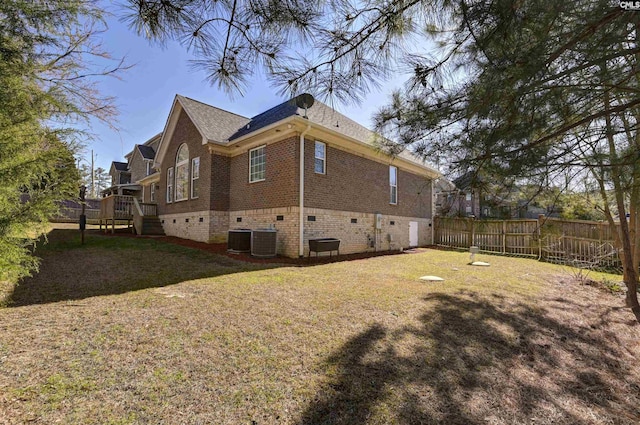 back of house with a yard, brick siding, central AC, and fence