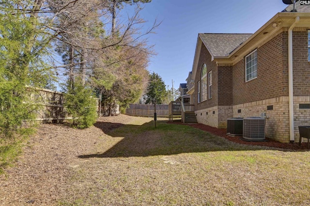 view of yard with central air condition unit and a fenced backyard