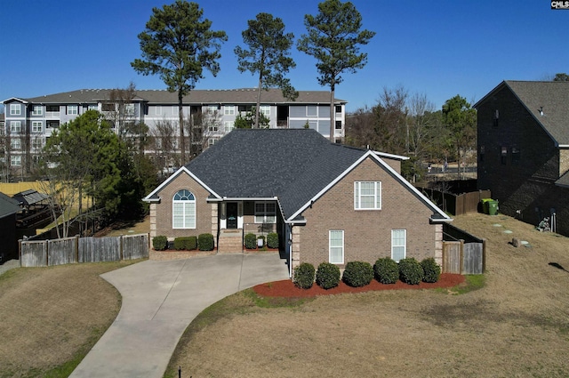 view of front of home with brick siding, fence, and a residential view