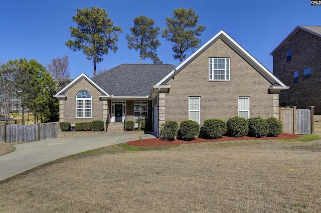 traditional-style house featuring concrete driveway, brick siding, and fence