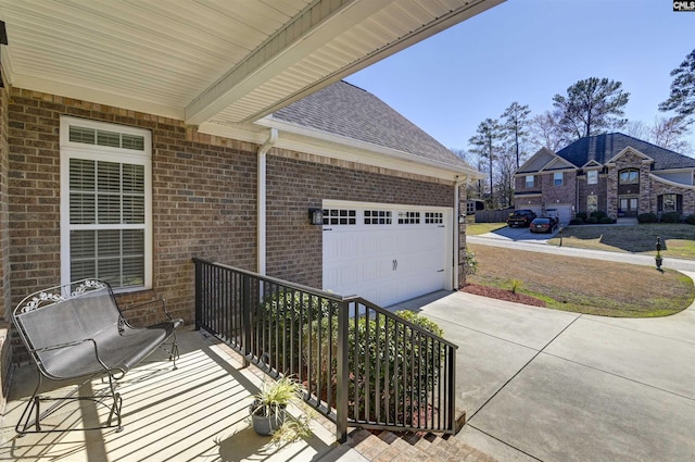 view of patio featuring concrete driveway and an attached garage