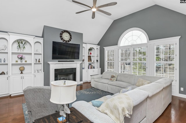 living area with dark wood finished floors, a fireplace, lofted ceiling, and ceiling fan